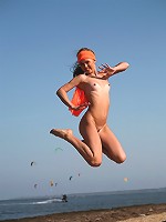 Small breasted gorgeous blonde with perky nipples jumping naked on the beach