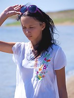 Sexy brunette teen posing bottomless on the beach