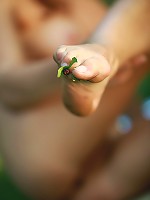 Curly haired blonde with natural firm breasts posing naked in the wood